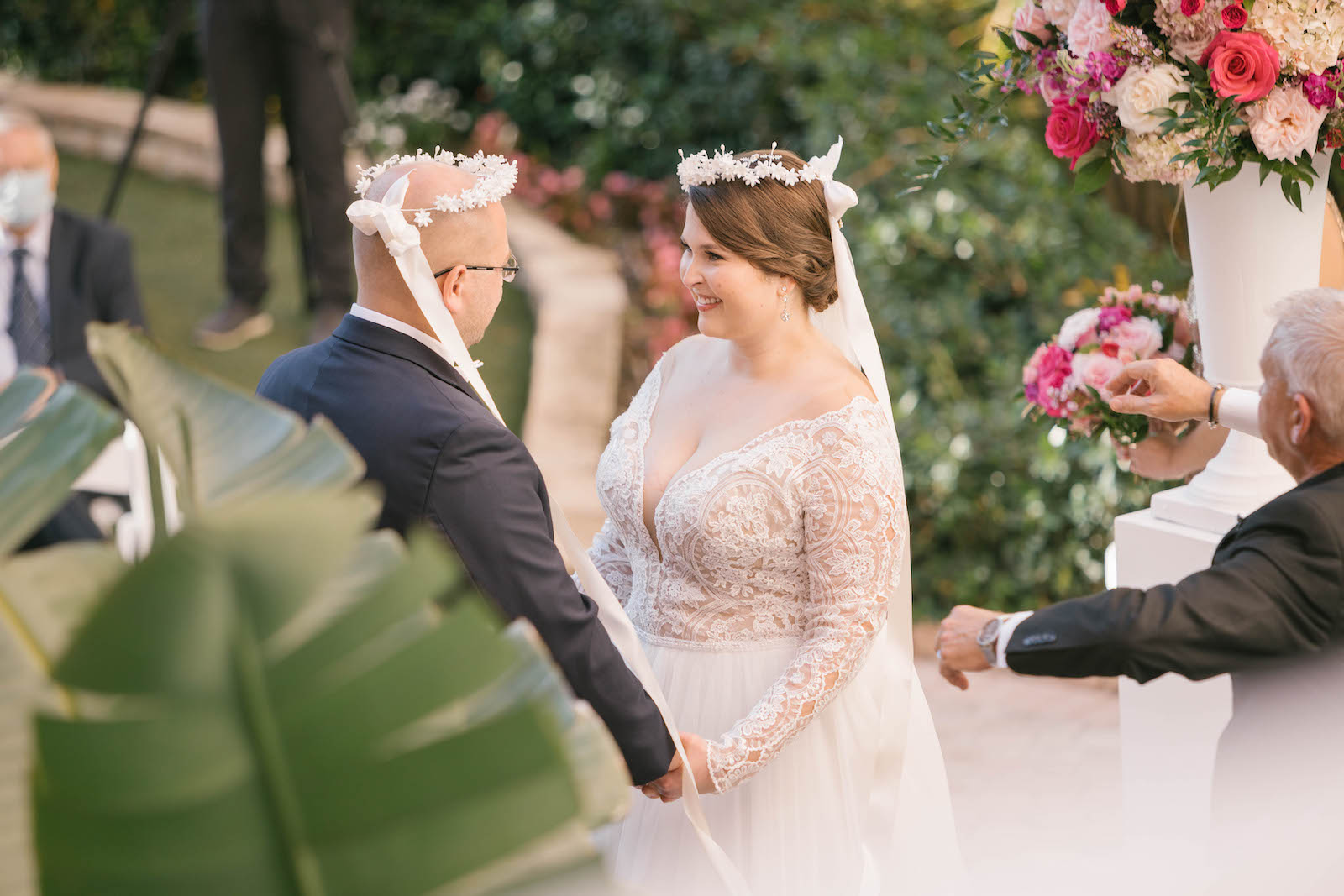 Florida Bride and Groom Wearing White Flower Crowns Exchanging Wedding Ceremony Vows on Steps of Historic St. Pete Wedding Venue The Don Cesar | Tampa Bay Wedding Planner Parties A'la Carte | Wedding Florist Bruce Wayne Florals