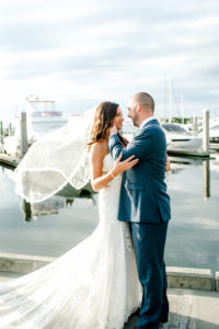 Bride and Groom Outdoor Portrait along Marina Dock at Tampa wedding venue westshore Yacht Club | Lace Strapless Sweetheart Scalloped Edge Train Wedding Dress Bridal Gown with Elbow Length Lace Edge Veil | Groom Wearing Classic Navy Suit | Dewitt for Love Photography