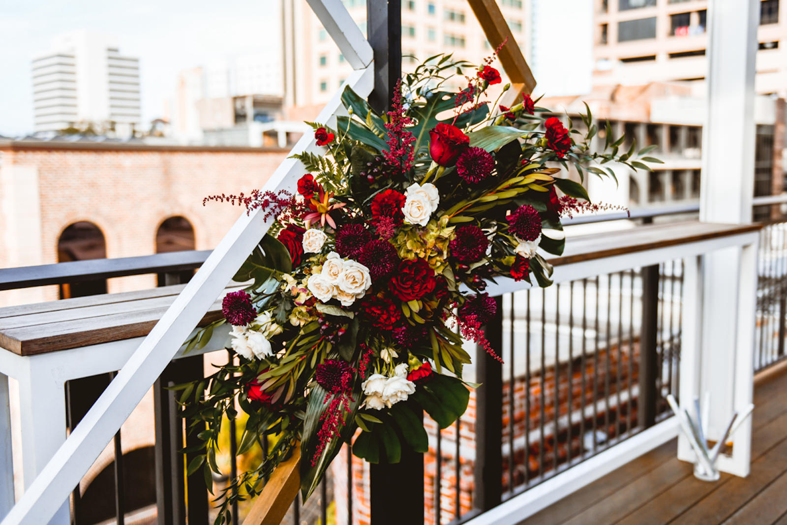 Florida Red and Ivory Roses and Flowers with Monstera Palm Tree Leaves | Tampa Wedding Planner Special Moments Event Planning | St. Pete Rooftop Wedding Venue Red Mesa Events