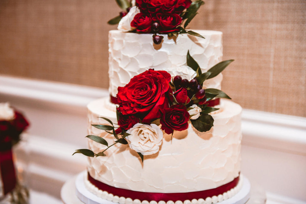 Two Tier White Textured Wedding Cake with Burgundy Ribbon and Red and Ivory Roses, Just Married Gold Glitter Cake Topper | Tampa Bay Wedding Cake Baker The Artistic Whisk