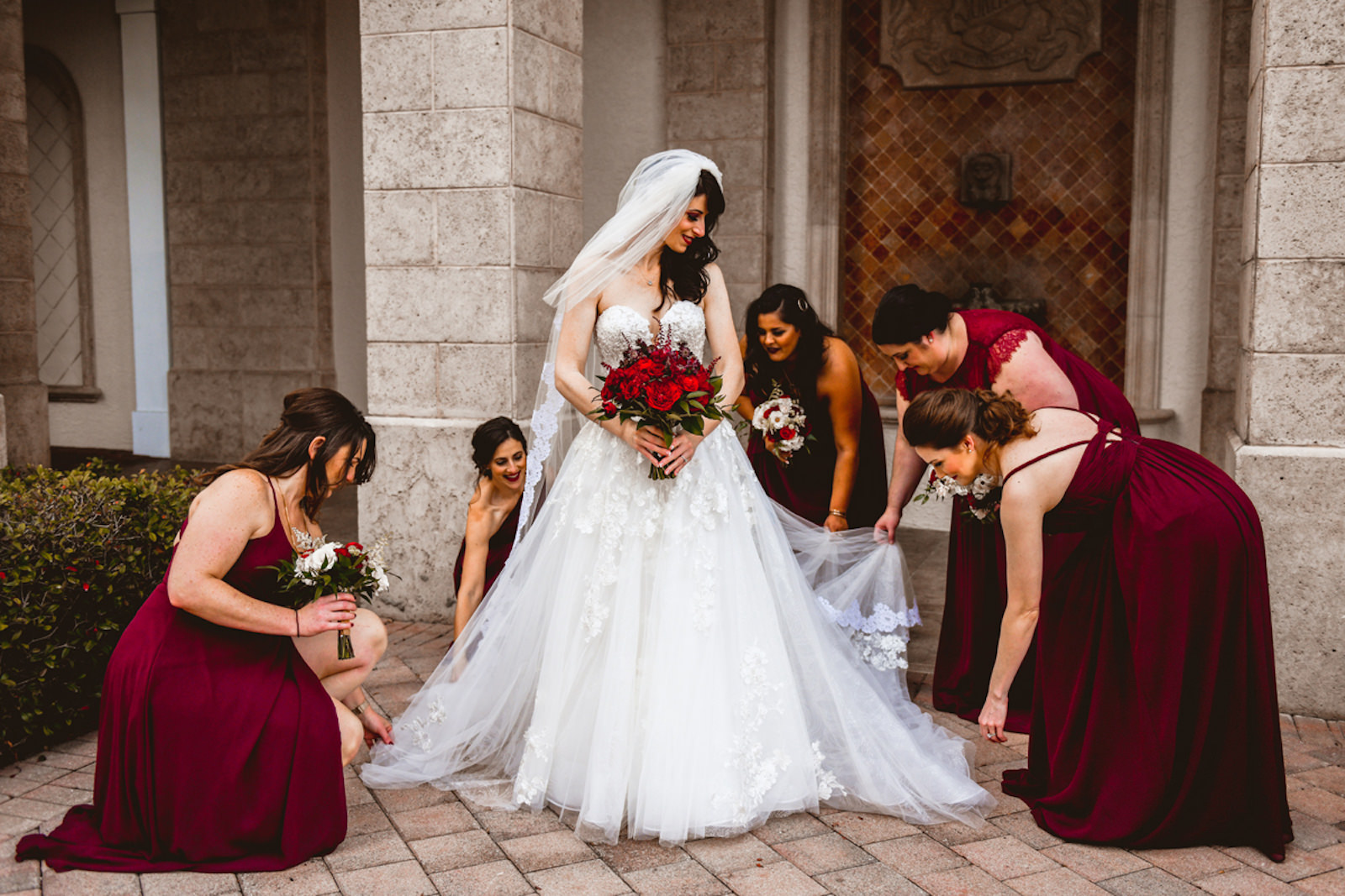 Florida Bride in Essense of Australia Strapless, Floral Applique and Tulle Skirt A-Line Wedding Dress Getting Ready with Bridesmaids in Burgundy Red Mix and Match Dresses Holding Red Floral Bouquets