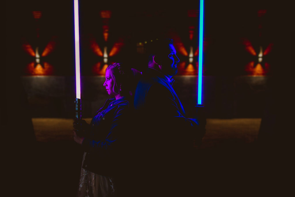 Unique and Fun Bride and Groom Wedding Photo in the Dark Holding Star Wars Light Sabers