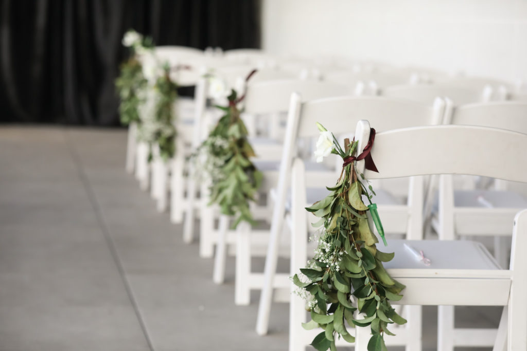 Outdoor Terrace Wedding Ceremony at Tampa Wedding Venue Hyde House | White Folding Garden Chairs with Greenery Swag Aisle Marker Arrangements