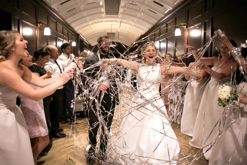 Bride and Groom Exit in Silver Confetti Streamer Send Off at Reception in Downtown Tampa | Bateau Neck Mikado Satin Martina Liana Simple Elegant Wedding Dress with Buttons Down Back | Groom in Classic Black Tux | Carrie Wildes Photography