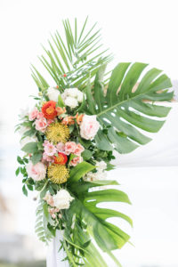 Tropical Wedding Ceremony Decor, Monstera and Palm Fronds, Pink and White Roses, Yellow Pincushion Proteas, Orange Floral Arrangement on Arch | Tampa Bay Wedding Planner Coastal Coordinating