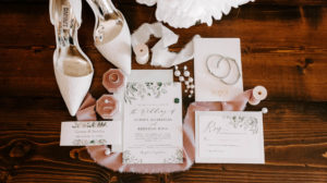 Tampa Wedding Invitation Suite Flat Lay Stationery with Greenery Motif | Blush Pink Velvet Ring Box with Bridal Accessories and Badgley Mischka Designer White Lace Pumps Bride Shoes