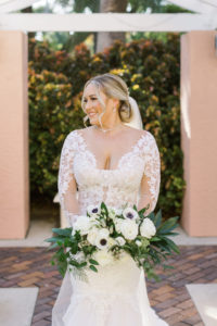 Tampa Bride Wearing Lace and Illusion Plunging Neckline Wedding Dress holding White Anemone. Rose and Greenery Floral Bouquet