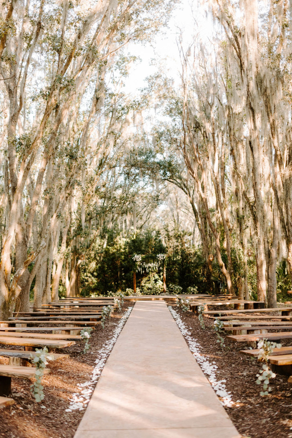 Outdoor Wedding Ceremony with Wood Benches and Wood Arch at Plant City Wedding Venue Florida Rustic Barn Weddings