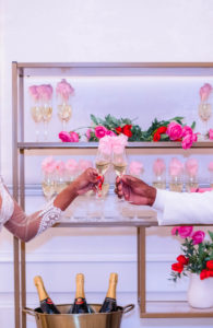 Champagne Wall Display with Pink and Red Rose Decor and Valentine Decor on Gold Shelving | EventFull Weddings