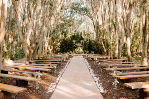 Outdoor Wedding Ceremony with Wood Benches and Wood Arch at Plant City Wedding Venue Florida Rustic Barn Weddings