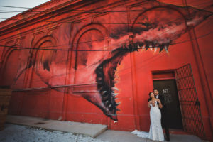 Unique Bride and Groom Photo in Front of Red Wall with Shark Mural in St. Petersburg