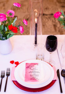 Valentine Inspired Place Setting with Ombre Menu Card with Reception Feasting Table with Hurricane Glass Centerpieces with Pink and Red Florals by A Chair Affair | EventFull Weddings