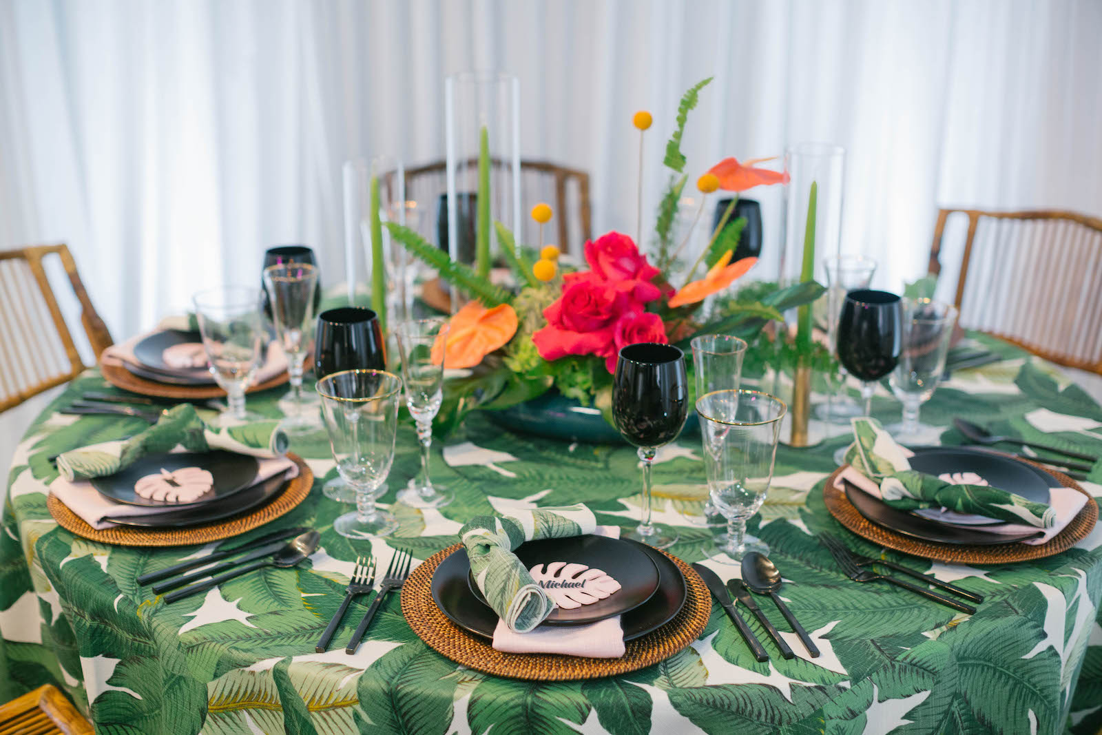 Palm Leave Linen with Wicker Charger, Black Place Setting and Dishes, and Vibrant Pink and Orange Centerpiece | Tropical Destination Beach Wedding Inspiration | Bellwether Beach Resort Styled with Love by Marry Me Tampa Bay