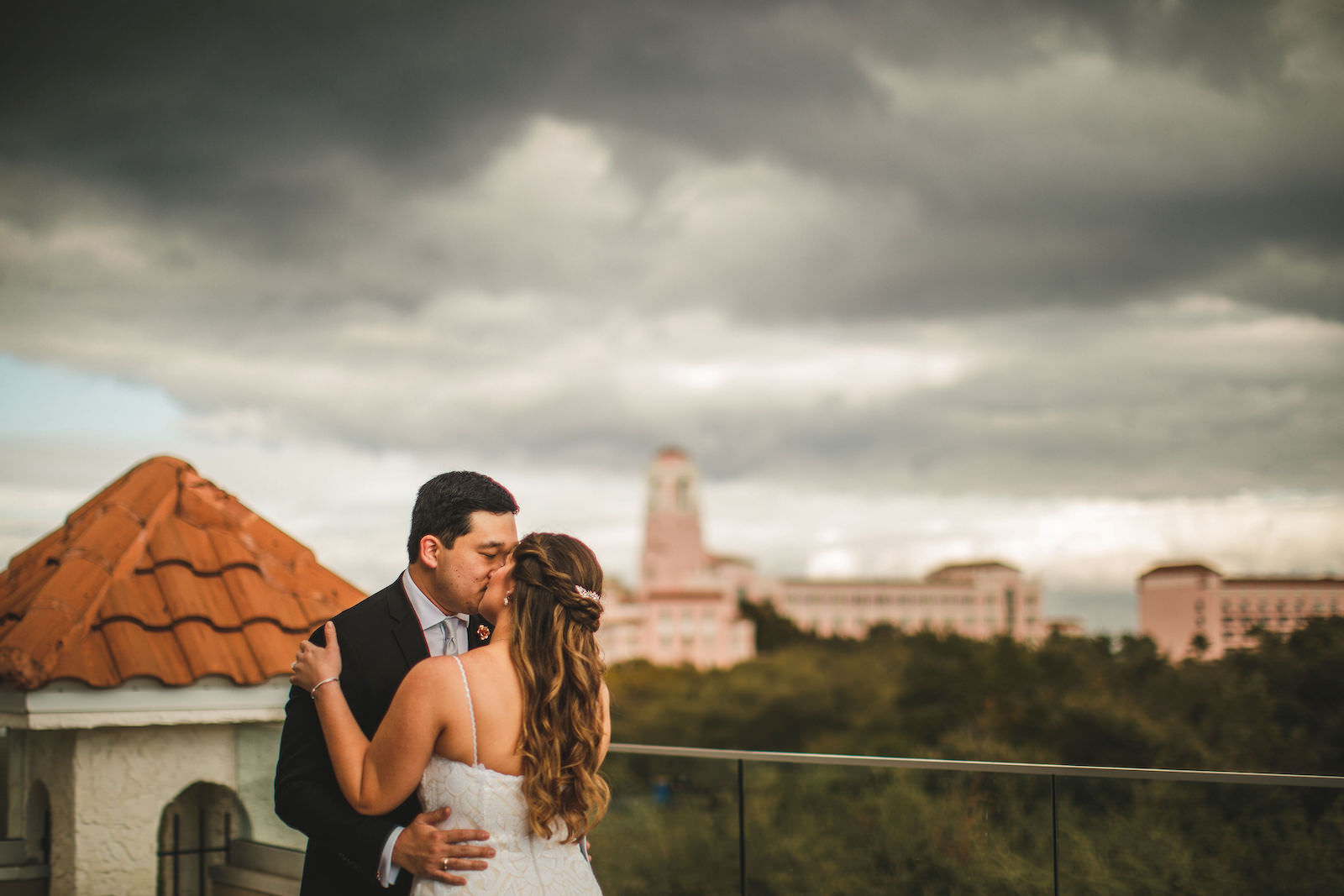 Tampa Bride and Groom Kissing on Rooftop Balcony of St. Pete Wedding Venue The Birchwood