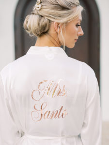 Tampa Bay Bride in White and Rose Gold Font Mrs Robe with Hair in Bun and Pearl Hair Piece | Tampa Bay Wedding Hair and Makeup Femme Akoi Beauty Studio