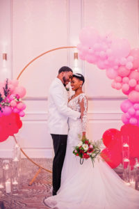 Bride and Groom Wedding Portrait with Wedding Ceremony Arch with Pink and Red Ombre Balloon Arch Decor | EventFull Weddings