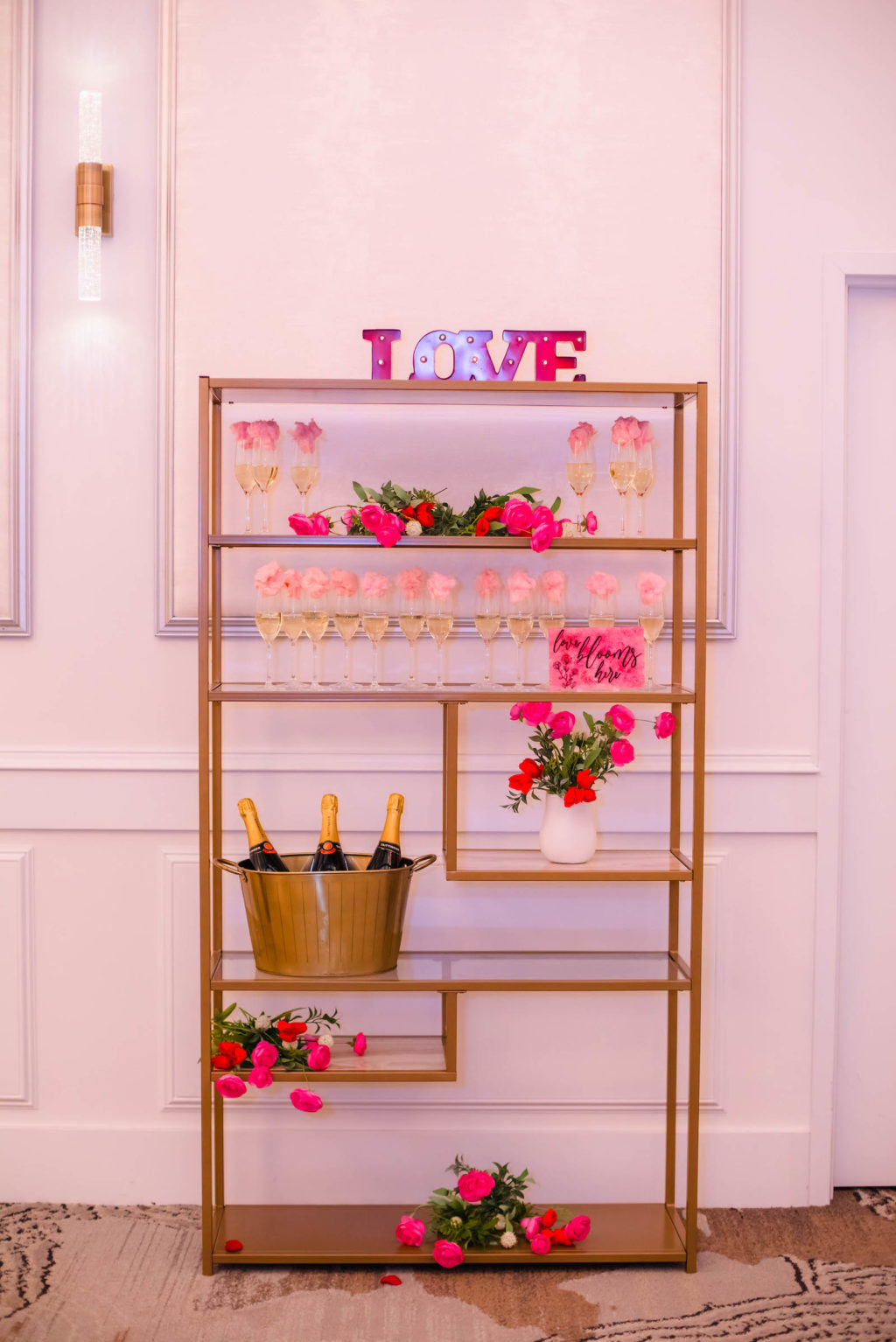 Champagne Wall Display with Pink and Red Rose Decor and Valentine Decor on Gold Shelving