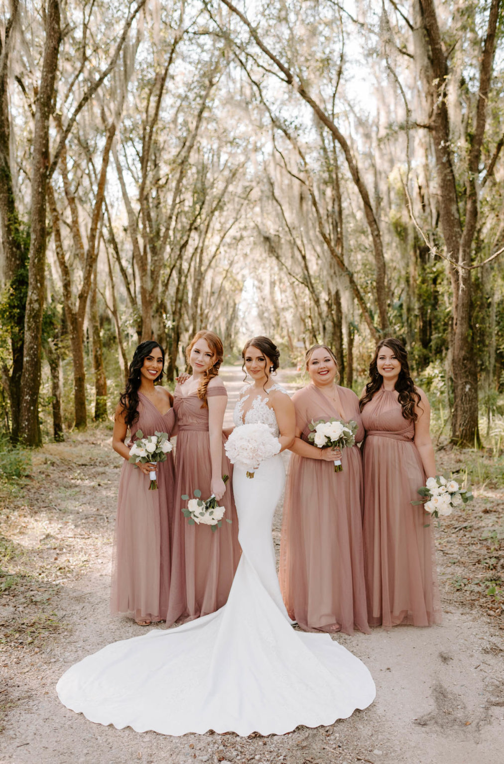 Outdoor Bridal Party Portrait | Illusion Lace Bodice Sheath Bridal Gown Wedding Dress | White Peony Bride Bouquet | Dusty Rose Mauve Pink Long Bridesmaid Dresses | White Rose and Greenery Bouquets