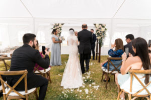 Bride in Romantic Lace Wedding Dress with Keyhole Back Walking with Father Down the Wedding Ceremony Aisle, Rustic Wooden Arch with Lush Floral Arrangements | Tampa Bay Wedding Planner Eventfull Weddings