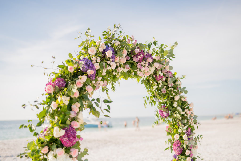 Elegant Beach Wedding Ceremony Decor, Round Arch with Greenery, Purple and Pink Flowers | Tampa Bay Wedding Photographer Kera Photography