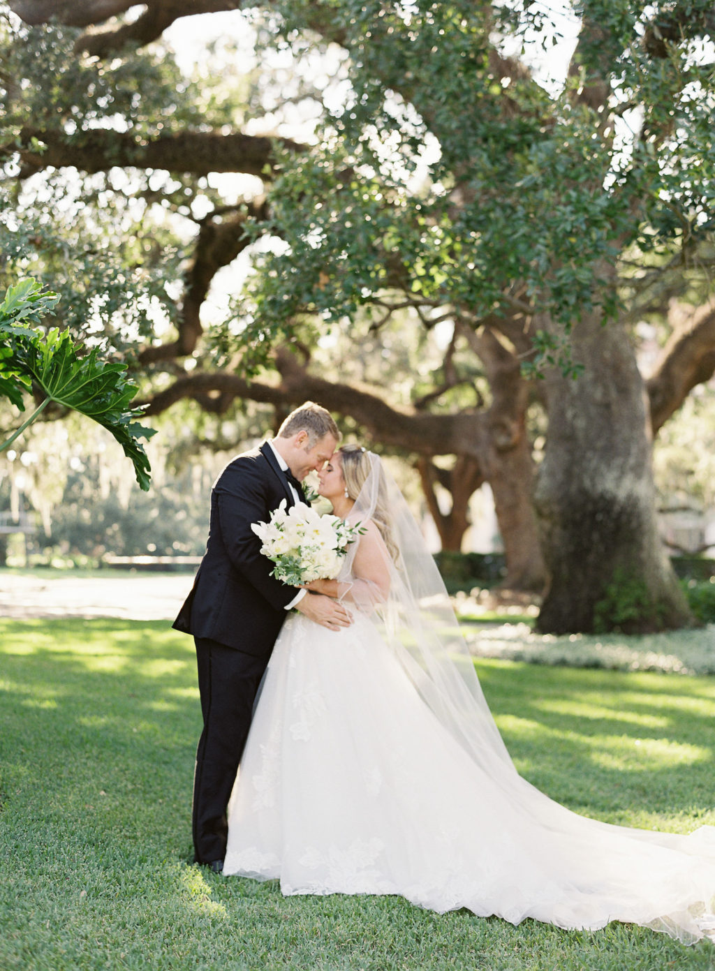 Traditional Bride in Ballgown Lace and Tulle Wedding Dress and Groom in Black Tuxedo