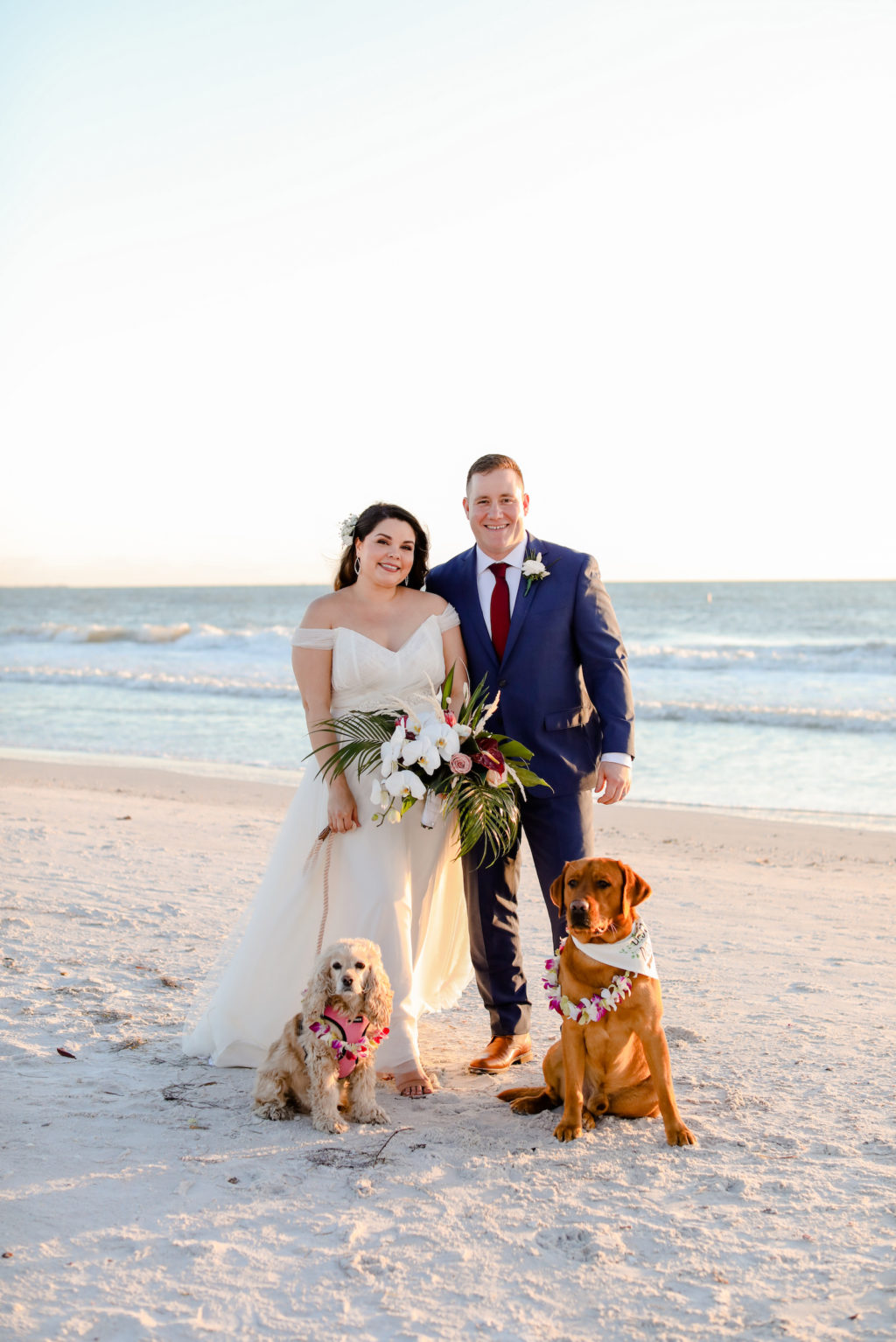 Florida Bride and Groom on the Beach During Sunset with Dogs Wearing Tropical Floral Leis | St. Pete Beach Wedding Venue Postcard Inn | Tampa Wedding Photographer Lifelong Photography Studio | Wedding Florist Iza's Flowers