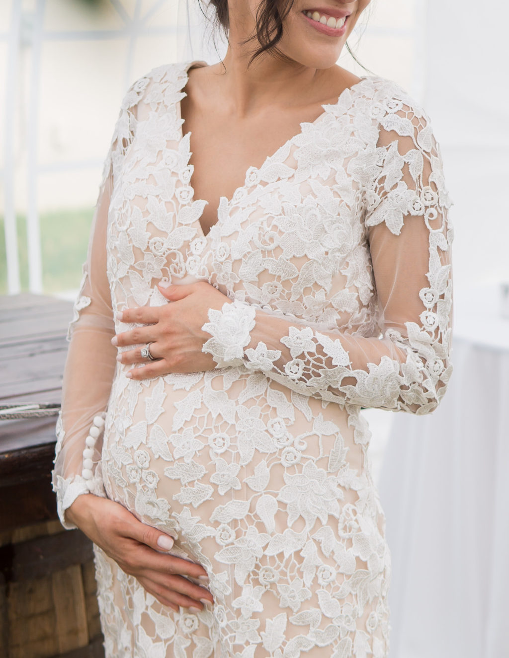 Bride Wearing Romantic Lace and Illusion Long Sleeve Wedding Dress Holding Pregnant Belly