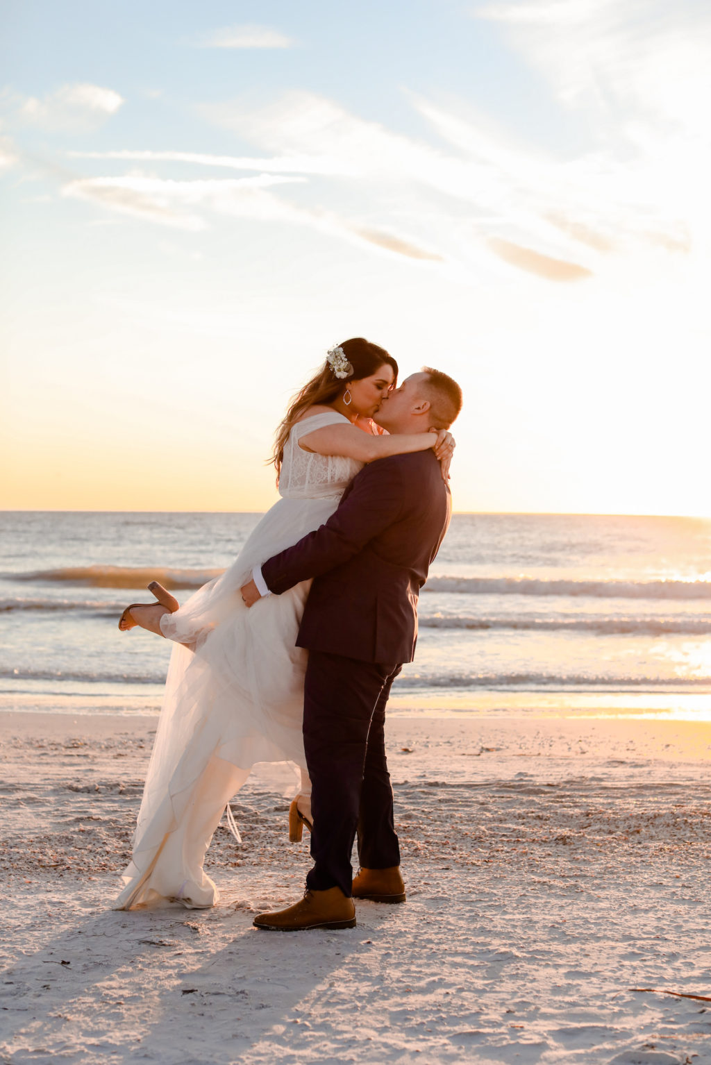Romantic Sunset Photo of Groom Holding Bride and Kissing on the Beach | St. Pete Beach Wedding Venue Postcard Inn | Tampa Wedding Photographer Lifelong Photography Studio