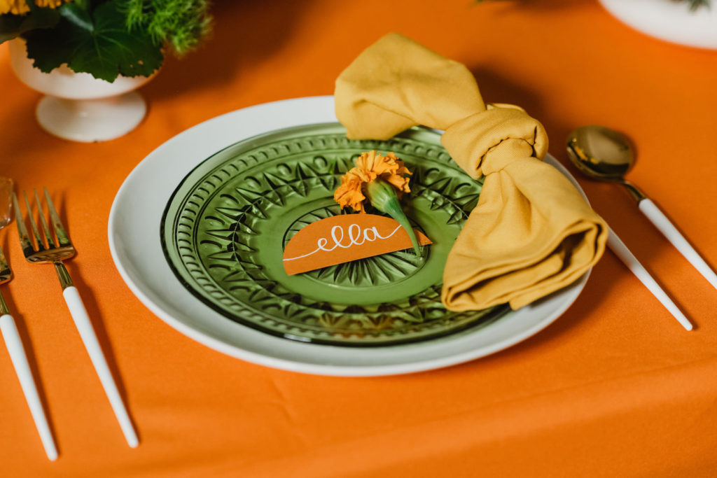 Retro Wedding Reception Decor, White Dinner Plate with Green Glass Vintage Salad Plate, Orange Geometric Name Place Card, Mustard Yellow Napkin, White Silverware