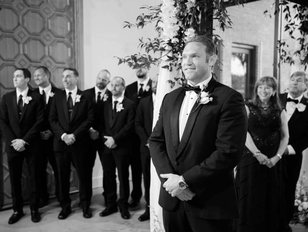 Traditional Groom Wearing Black Tuxedo Watching Bride Walking Down the Wedding Ceremony Aisle | Tampa Bay Wedding Venue Hyde House