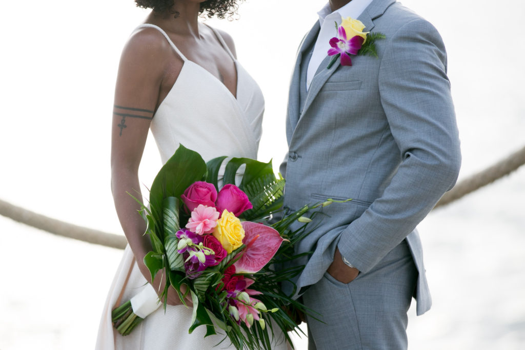 Boho Florida Bride Wearing Elegant Flowy Wedding Dress, Holding Modern Tropical Inspired Floral Bouquet with Vibrant Roses, Bright Pink Flowers, Monstera, and Palm Leaves, Groom Boutonnière a Purple Hibiscus and Yellow Rose | Tampa Bay Wedding Photographer Carrie Wildes Photography | South Tampa Wedding Planners Socialite Events | Wedding Dress Boutique Truly Forever Bridal Tampa