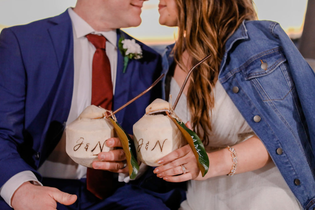Florida Tropical Bride in Wedding Dress and Jean Jacket and Groom Cheering with Personalized Monogram Coconuts | Tampa Bay Wedding Photographer Lifelong Photography Studio