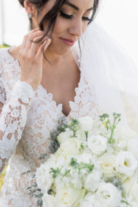 Tampa Bride in Romantic Lace Long Sleeve Wedding Dress Holding White Floral Bouquet | Wedding Hair and Makeup Femme Akoi Beauty Studio
