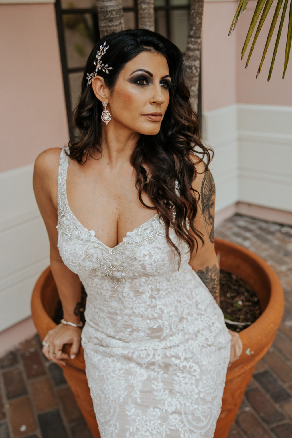 Outdoor Bridal Portrait | Bride Wearing Loose Curls and an Illusion Lace V Neck Sheath Bridal Gown Wedding Dress with Champagne Liner by Ashley and Justin Bride