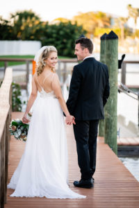 Florida Bride and Groom Holding Hands on Dock | St. Pete Wedding Venue Hotel Zamora | Tampa Wedding Dress Isabel O'Neil Bridal