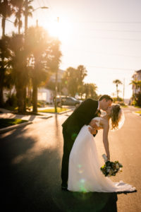 Romantic Groom Dip Kissing Bride Sunset on the Street Wedding Photo | Tampa Bay Wedding Dress Isabel O'Neil Bridal