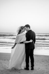Black and White Groom and Bride Wearing White Fur Shawl on Beach | Tampa Bay Wedding Dress Isabel O'Neil Bridal | Florida Beach Wedding Portraits