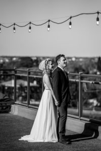 Romantic Intimate Bride Holding Hands with Groom from Behind on Rooftop Waterfront St. Pete Wedding Venue Hotel Zamora | Tampa Wedding Dress Isabel O'Neil Bridal | First Touch Wedding Portrait