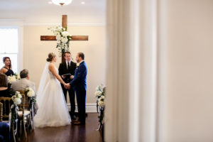 Classic Traditional Bride and Groom Exchanging Wedding Ceremony Vows at Wooden Cross Altar with White Floral Arrangements | Tampa Bay Wedding Photographer Lifelong Photography Studio | Wedding Planner Core Concepts | Wedding Rentals A Chair Affair | Kate Ryan Event Rentals