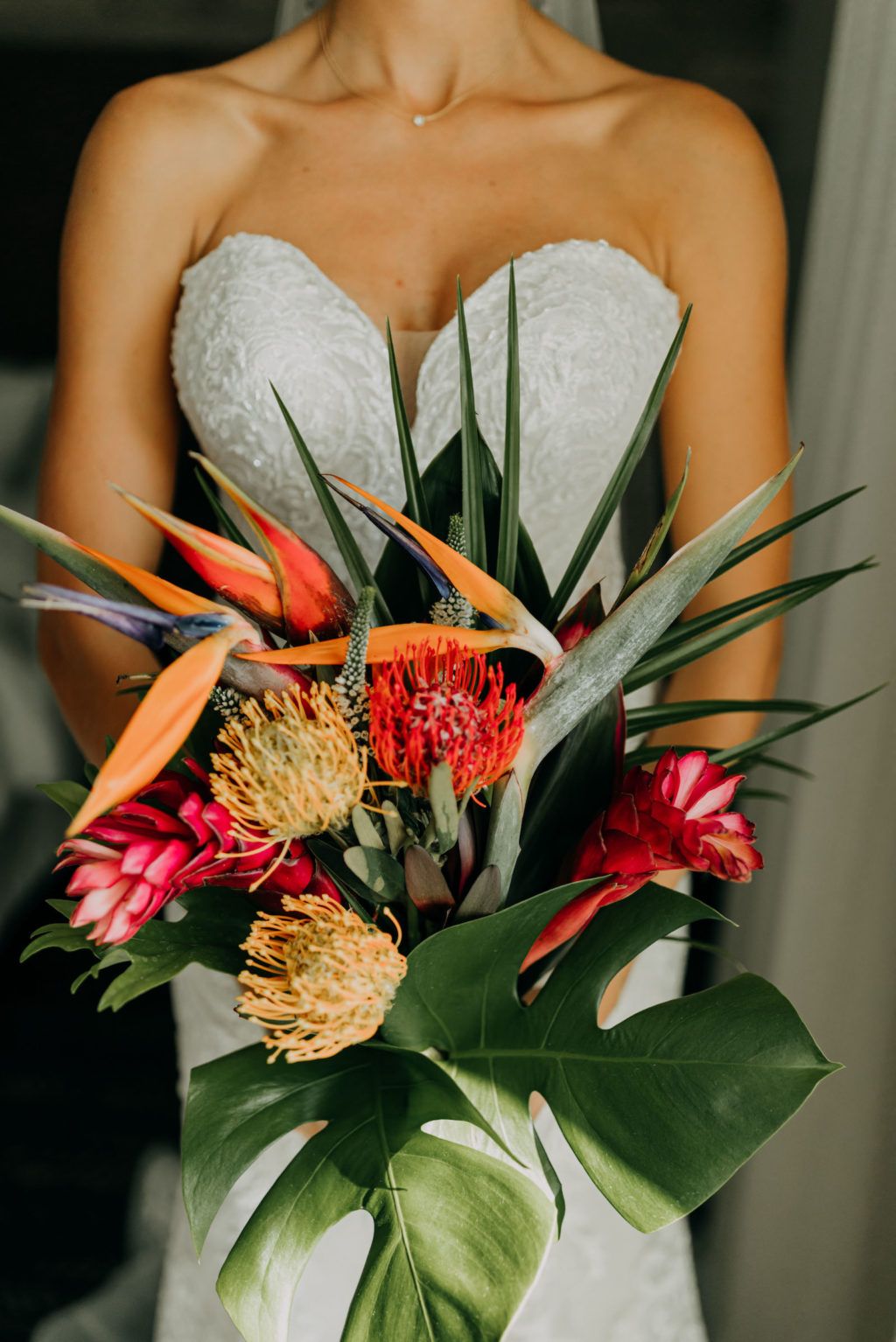 Florida Bride in Lace and Illusion Strapless Wedding Dress Holding Tropical Floral Bouquet, Yellow and Red Pincushion Proteas, Pink Ginger, Birds of Paradise, Monstera Palm Tree Leaves | Tampa Bay Wedding Photographer Amber McWhorter Photography