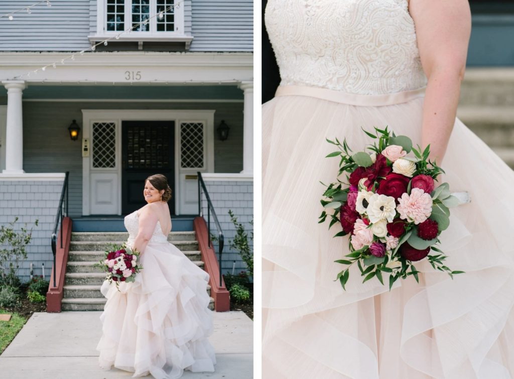 Romantic Bride in Lace Bodice and Illusion High Neckline, Tulle Blush Lining Skirt Ballgown Wedding Dress Holding Jewel Toned, White Anemone, Pink and Red Roses with Greenery Floral Bouquet Out Front of Tampa Wedding Venue The Orlo | Wedding Florist Brides N' Blooms Wholesale Design