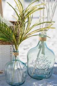 St. Pete Beach Wedding Aisle Flower Arrangement Centerpieces Recycled Glass Bottles with Palm Greenery
