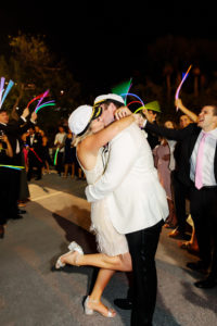 Nautical Bride in Short Wedding Reception Dress, Sailor Hat, and Groom in White Tuxedo with Sailor Hat Kissing During Glowsticks Wedding Exit | Tampa Bay Wedding Photographer Limelight Photography