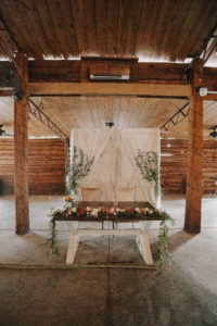Rustic Barn Wedding Reception, Wooden Table with Floral and Greenery Garland, White Drapery Backdrop | Plant City Wedding Venue Florida Rustic Barn Weddings