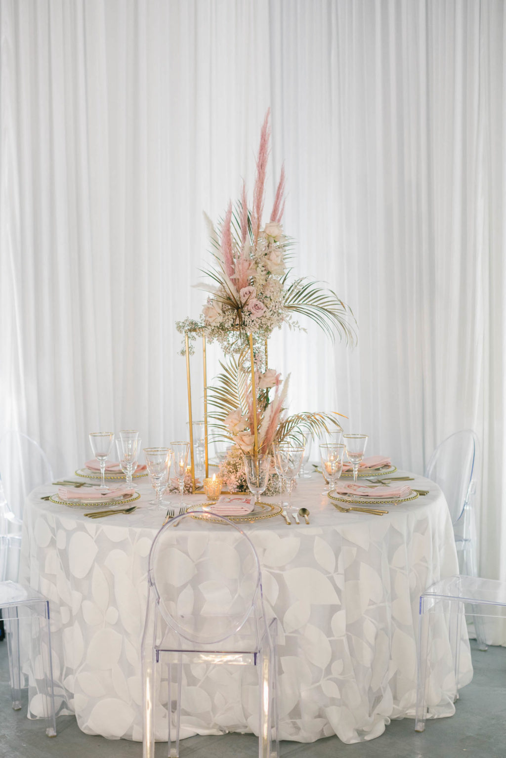 Clearwater Beach Wedding Venue Bellwether Beach Resort Styled With Love Something Bleu by McKenna Bleu | Instagram Wedding Designer Inspiration | Clear Ghost Chairs and White Botanical Print Reception Table Linen with Gold Boho Centerpiece with Pampas Grass Roses and Palm Leaves