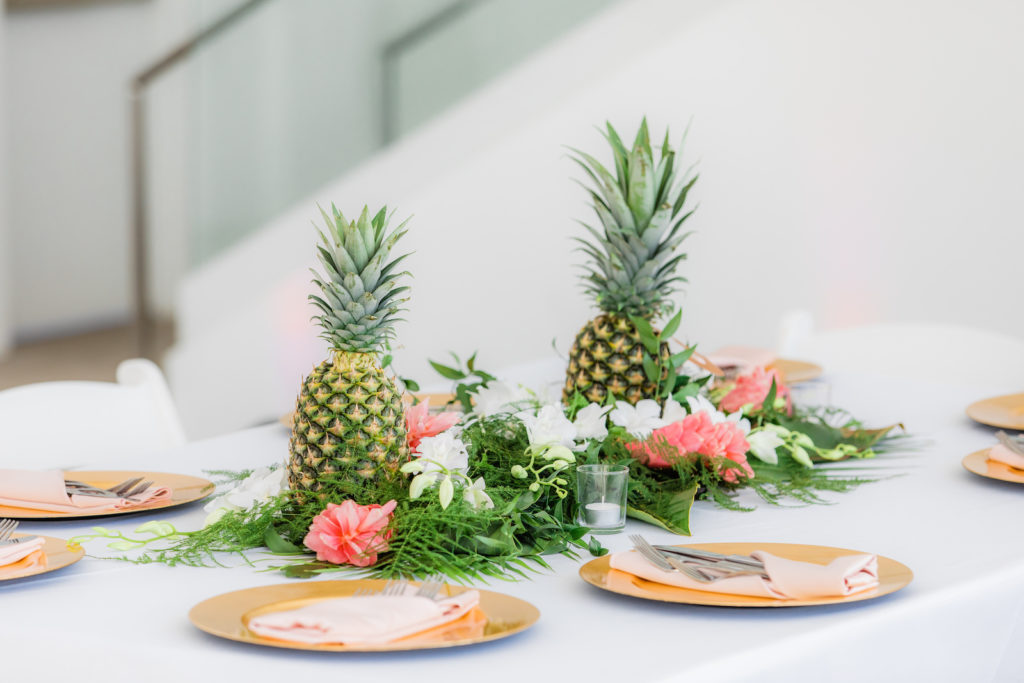 Elegant Tropical Wedding Reception Decor, Pineapples, Palm Fronds, Pink Ginger Floral Centerpiece, Gold Chargers | Tampa Bay Wedding Florist Iza's Flowers