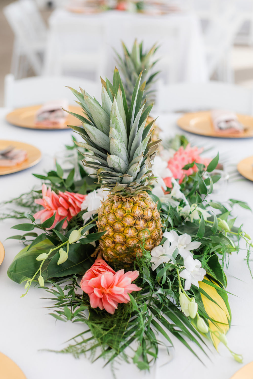 Elegant Tropical Wedding Reception Decor, Pineapples, Palm Fronds, Pink Ginger Floral Centerpiece, Gold Chargers | Tampa Bay Wedding Florist Iza's Flowers