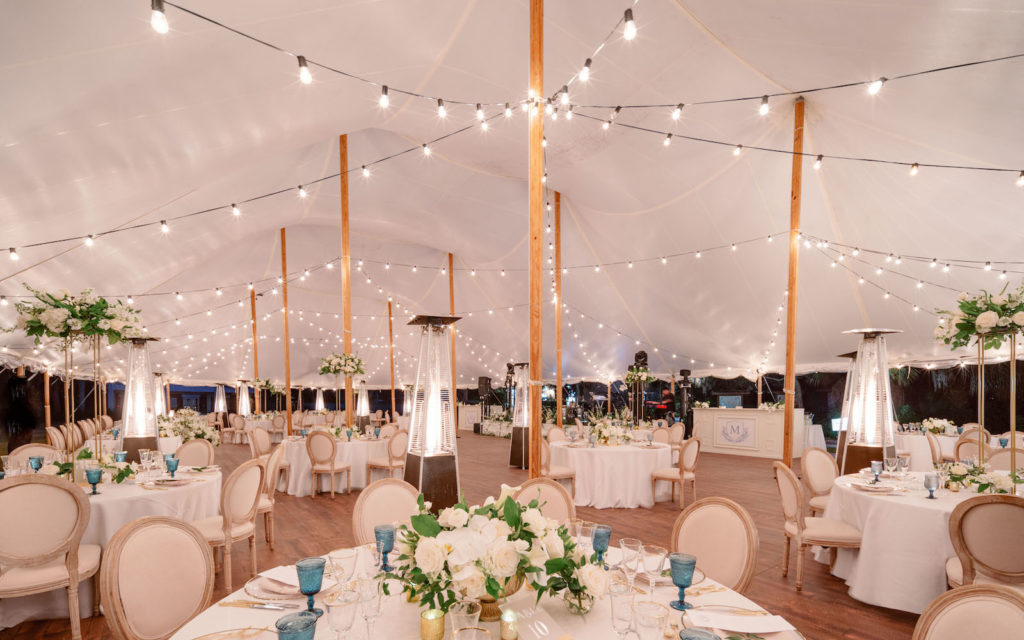 Elegant Luxurious Tent Wedding Reception, String Lights, French Country Upholstered Dining Chairs, White Floral Centerpieces, Blue Water Goblets | Tampa Bay NK Productions Wedding Planning