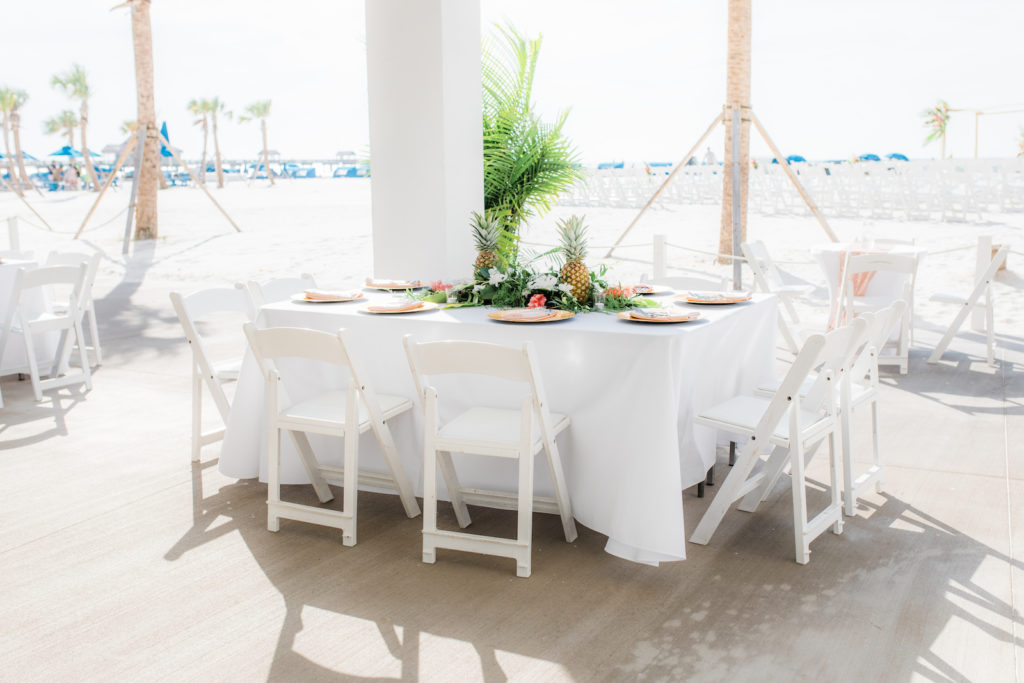 Elegant Tropical Wedding Reception Decor, Long Tables with White Linens, Folding Chairs, Pineapples Centerpieces, Gold Chargers | Wedding Venue Hilton Clearwater Beach