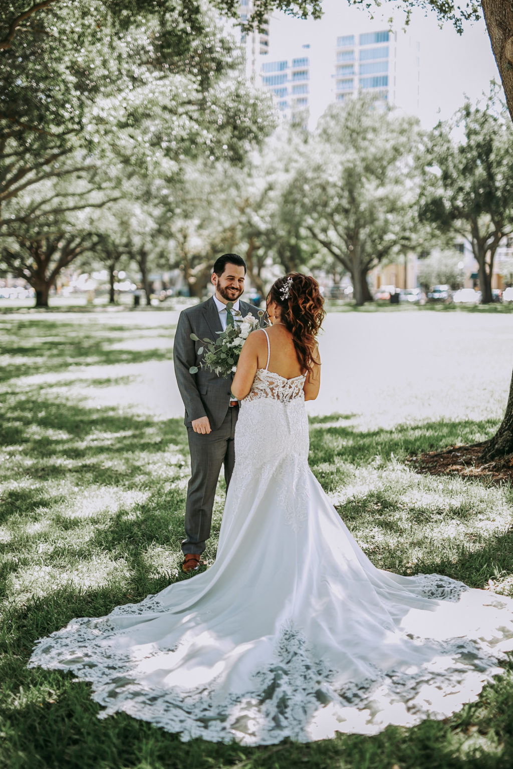 Outdoor Bride and Groom First Look Portrait | Groom Wearing Classic Charcoal Grey Suit with Green Tie | Lace Fit and Flare Mermaid Spaghetti Strap Wedding Dress Bridal Gown with Scallop Edge Lace Train Hem